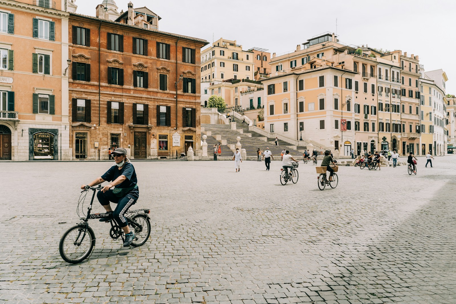 people riding bicycle on road near brown concrete building during daytime