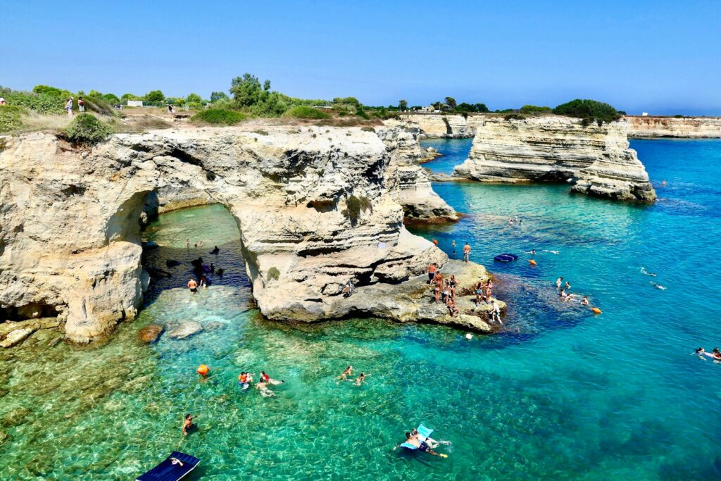 people swimming on sea during daytime